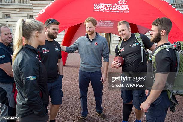 Prince Harry speaks with members of the Walking With The Wounded team in the forecourt of Buckingham Palace after their latest endeavour, the Walk Of...