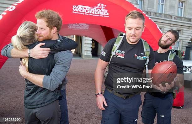 Prince Harry hugs Kirsty Ennis , a helicopter door gunner and Afghan veteran as he meets with members of the Walking With The Wounded team in the...