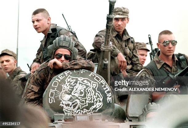 Members of the Russian Army sit atop an armored personal vehicle with a logo of "Soldier of Fortune" 18 July 1995 in Grozny, capital of the breakaway...
