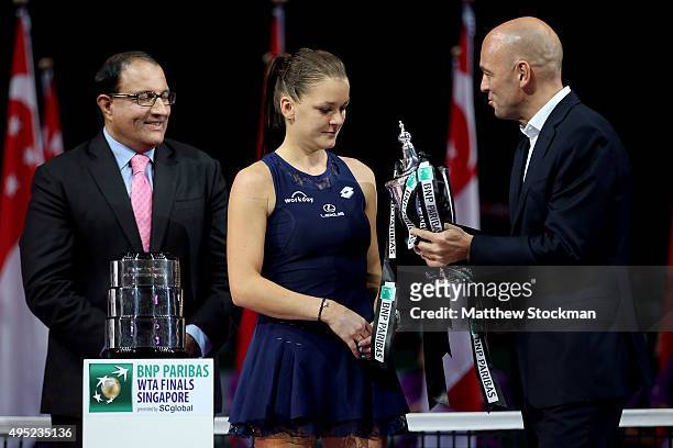 Paribas' Pierre Veyres presents Agnieszka Radwanska of Poland the Billie Jean King Trophy after she defeated Petra Kvitova of Czech Republic in the...