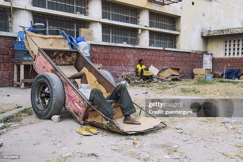 Futebol de homem descansando em um carrinho de mão, Kinshasa, Congo