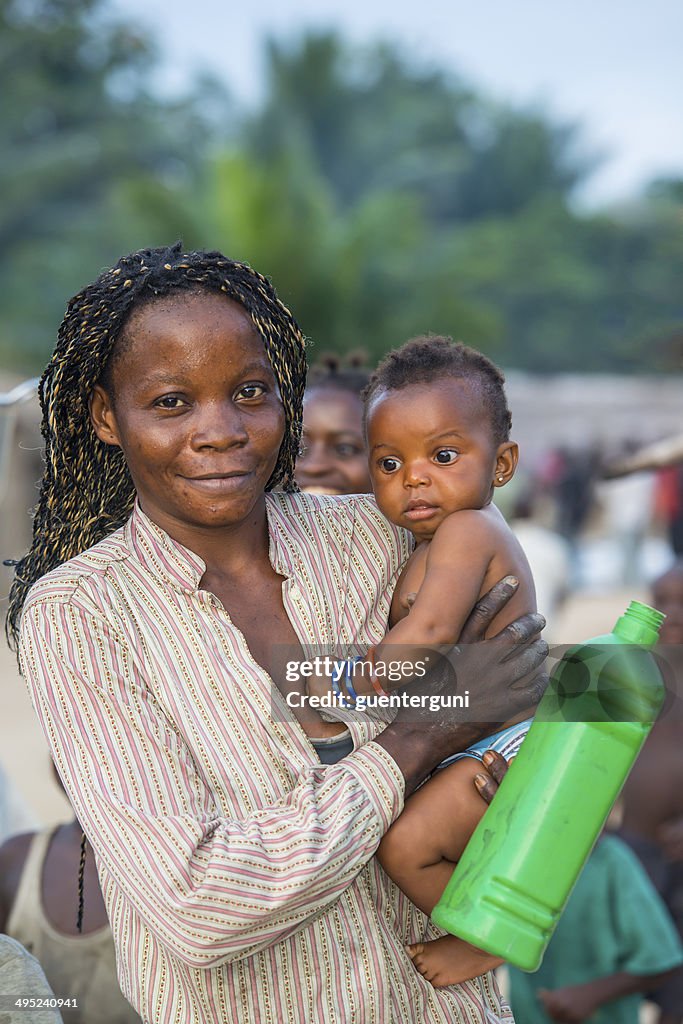 Congolese woman carrying here baby and a waterbottle