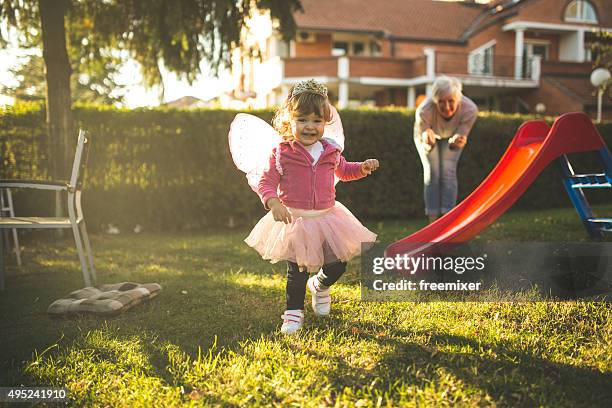 little girl having a great time with grandmother - toddler girl dress stockfoto's en -beelden