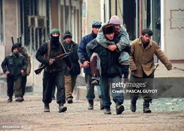 Civilians run 12 January 1995 from a basement to take cover during heavy shelling of central Grozny. Russia launched 14 January an all-out air and...