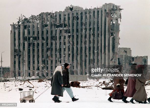 Chechen women and men pass in February 1996 by the destroyed presidential palace in Grozny, capital of the breakaway southern republic of Chechnya....