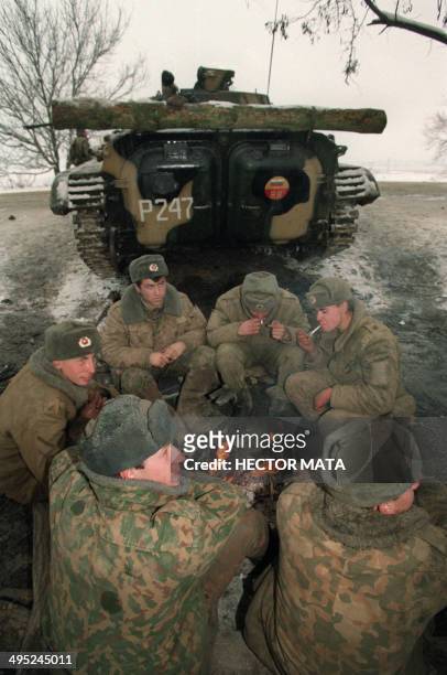 Russian soldiers sit around a fire in Khassavyurt, on the Chechen-Daghestan border, on December 22, 1994 as they wait for instructions to storm...