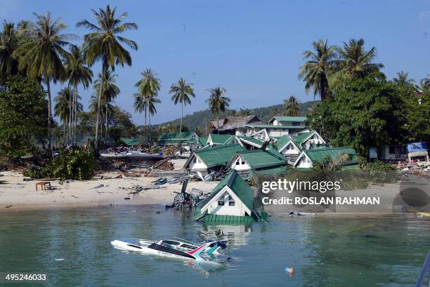 Boat and one of the gift shops building submerge on the beach of Phi Phi island in southern Thailand's holiday resort which was destroyed by a tidal...