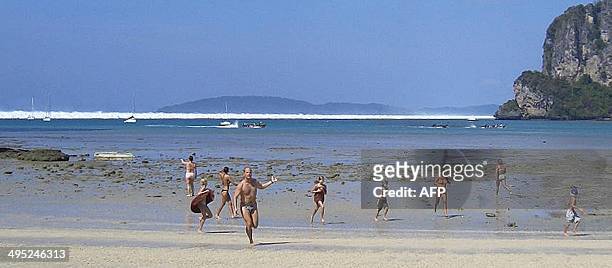 Foreign tourists react as the first of six tsunami starts to roll towards Hat Rai Lay Beach, near Krabi in southern Thailand, 26 December 2004. The...