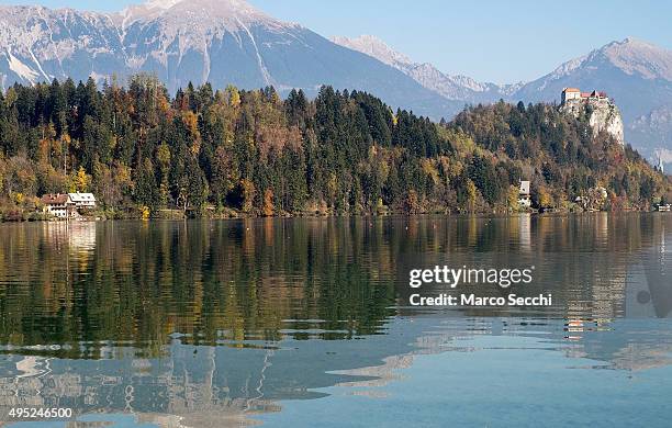 Reflections of autumn foliage and the Castle on Bled Lake on November 1, 2015 in Bled, Slovenia. Bled Lake in the Julian Alps is known as one of the...