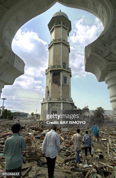 Acehnese walk through the rubbish at the biggest mosque in Banda Aceh, 28 December 2004, following the devastating earthquake and resulting tsunami...