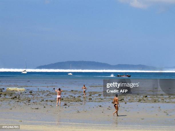 Foreign tourists react on the beach as the first of six tsunami start to roll towards Hat Rai Lay Beach, near Krabi in southern Thailand, 26 December...