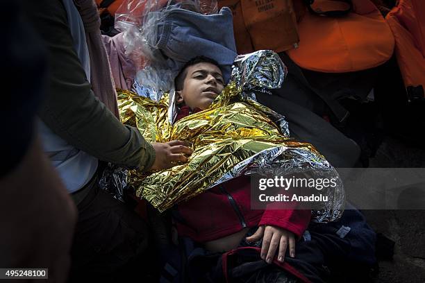 Group of refugees, succeeded to arrive the coast, are seen after a boat carrying refugees sank off the coast of Greece's Lesbos Island on November...