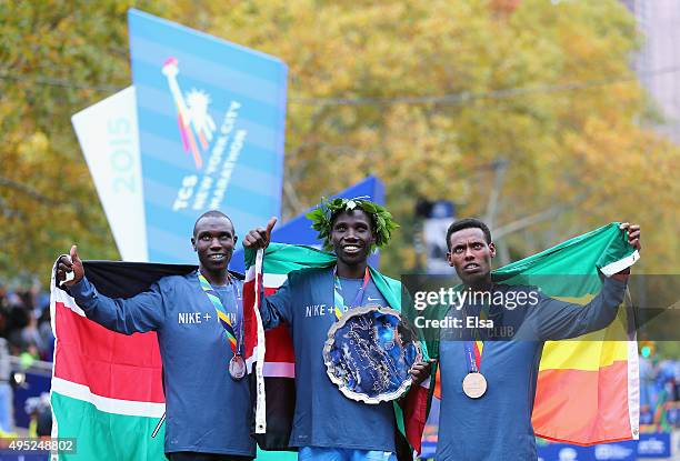 Stanley Biwott of Kenya poses with the first place trophy alongside second place Geoffrey Kipsang Kamworor of Kenya and third place Lelisa Desisa of...