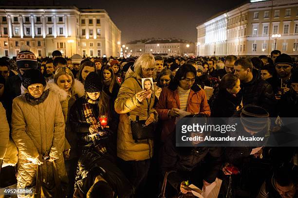 Woman brings a photo of one of the victims of the crash as people mourn the victims of Airbus A321 crash at the Palace Square on November 1, 2015 in...