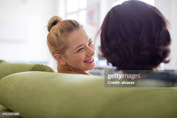 happy young couple sitting on sofa - back of heads stock pictures, royalty-free photos & images