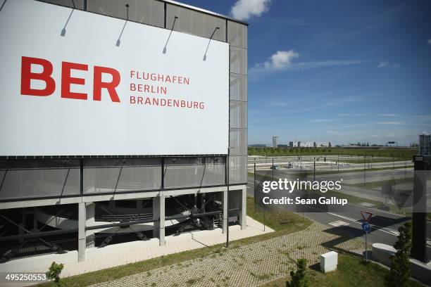 Billboard hangs on th side of a parking garage next to an empty parking lot at the unfinished new BER Willy Brandt Berlin Brandenburg International...