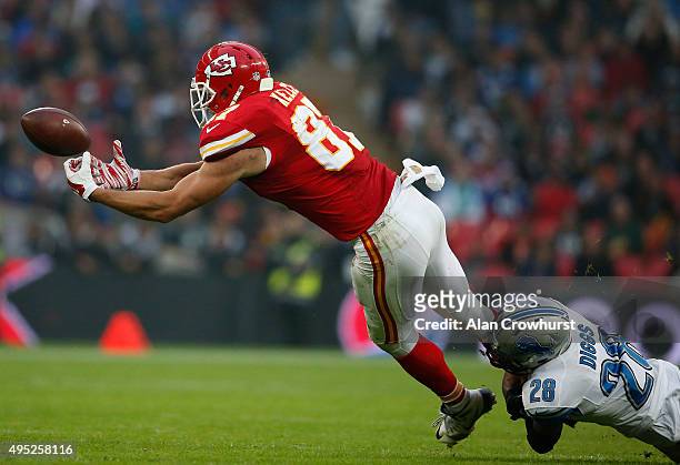 Travis Kelce of Kansas City Chiefs drops a pass as he is tackled by Quandre Diggs during the NFL game between Kansas City Chiefs and Detroit Lions at...