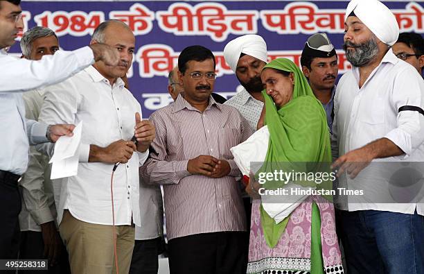 Delhi Chief Minister Arvind Kejriwal and Deputy Chief Minister Manish Sisodia distributing Cheque for enhanced compensation of Rs. Five lakh each to...