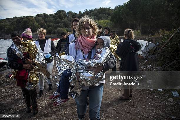 Group of refugees, succeeded to arrive the coast, are seen after a boat carrying refugees sank off the coast of Greece's Lesbos Island on November...