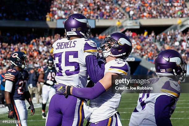 Marcus Sherels of the Minnesota Vikings celebrates with Adam Thielen after scoring a touchdown on a 65 yard punt return against the Chicago Bears in...