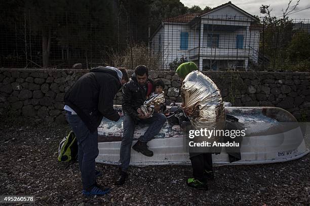 Group of refugees, succeeded to arrive the coast, are seen after a boat carrying refugees sank off the coast of Greece's Lesbos Island on November...