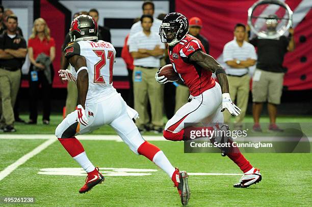 Julio Jones of the Atlanta Falcons runs past Alterraun Verner of the Tampa Bay Buccaneers after a catch during the first half at the Georgia Dome on...