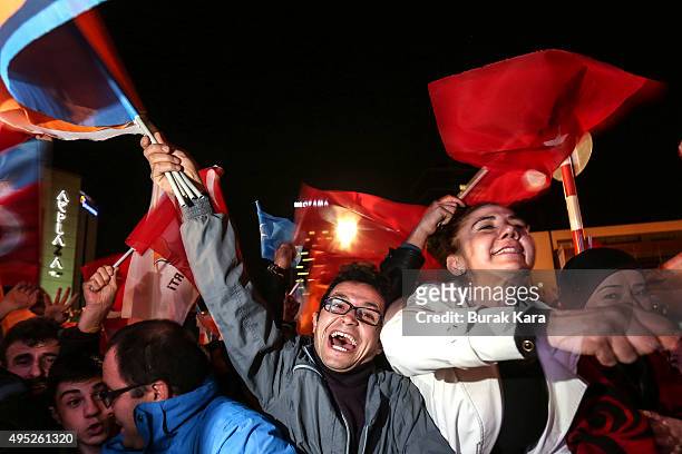 People wave flags outside the ruling AK Party headquarters after the party won a critical election after loosing a majority back in June on November...