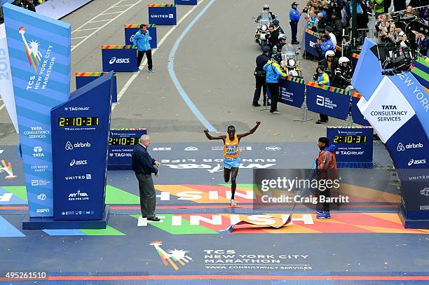 Stanley Biwott of Kenya crosses the finish line to win the Pro Men's division, New York City Police Commissioner William J. Bratton and Filmmaker and...