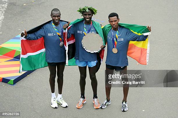 Stanley Biwott of Kenya poses with the first place trophy alongside second place Geoffrey Kipsang Kamworor of Kenya and third place Lelisa Desisa of...