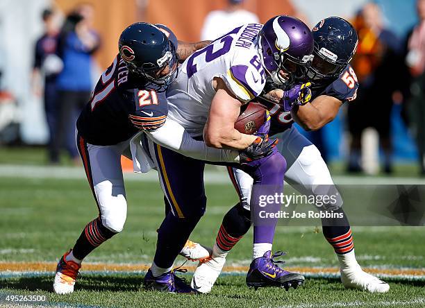 Kyle Rudolph of the Minnesota Vikings carries the football against Ryan Mundy and Jonathan Anderson of the Chicago Bears in the first quarter at...