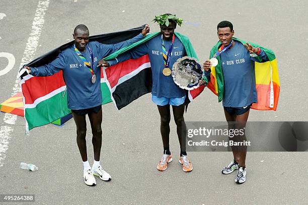 Stanley Biwott of Kenya poses with the first place trophy alongside second place Geoffrey Kipsang Kamworor of Kenya and third place Lelisa Desisa of...