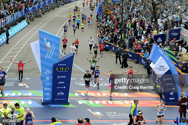 Athletes cross the finish line at TAG Heuer Official Timekeeper and Timepiece of 2015 TCS New York City Marathon on November 1, 2015 in New York City.