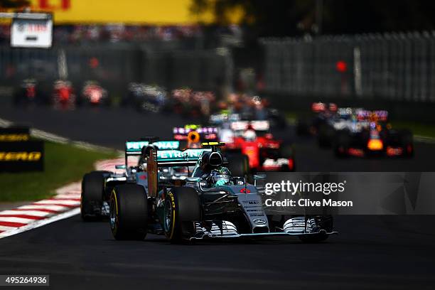 Nico Rosberg of Germany and Mercedes GP leads Lewis Hamilton of Great Britain and Mercedes GP, Daniil Kvyat of Russia and Infiniti Red Bull Racing,...