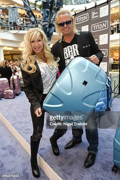 Robert And Carmen Geiss pose with a Titan suitcase during the opening event of a new Titan Shop on June 2, 2014 in Osnabruck, Germany.