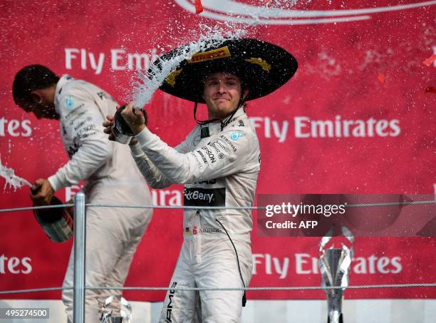 Mercedes AMG Petronas German driver Nico Rosberg celebrates his victory with teammate Lewis Hamilton on the podium after winning the Formula 1 Grand...