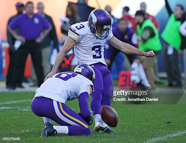 Blair Walsh of the Minnesota Vikings kicks the game-winning field goal out of the hold of Jeff Locke against the Chicago Bears at Soldier Field on...