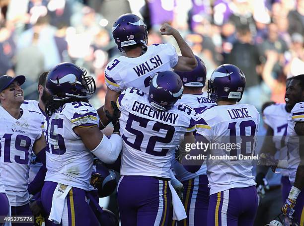 Blair Walsh of the Minnesota Vikings is lifted up by teammate Chad Greenway as the celebrate after Walsh kicked the game-winning field goal against...