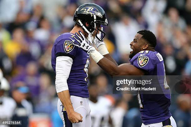 Kicker Justin Tucker of the Baltimore Ravens celebrates with cornerback Anthony Levine of the Baltimore Ravens after kicking the game winning field...