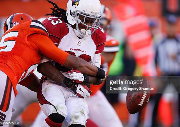 Chris Johnson of the Arizona Cardinals fumbles during a third quarter run while being hit by Armonty Bryant of the Cleveland Browns at FirstEnergy...