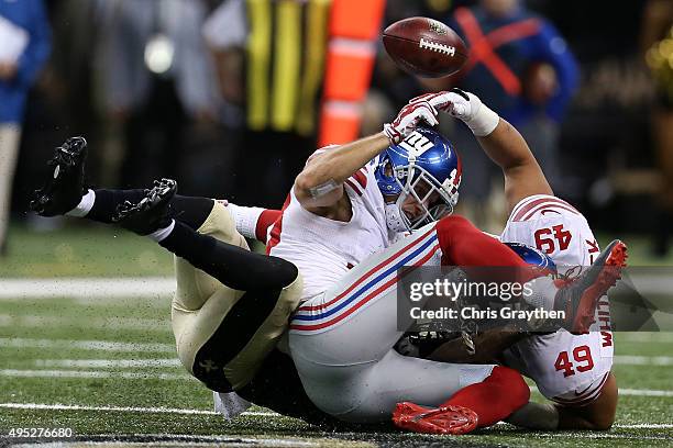 Marcus Murphy of the New Orleans Saints has the ball stripped by New York Giants defensive back Craig Dahl at Mercedes-Benz Superdome on November 1,...