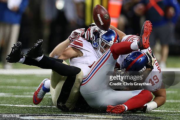 Marcus Murphy of the New Orleans Saints has the ball stripped by New York Giants defensive back Craig Dahl at Mercedes-Benz Superdome on November 1,...
