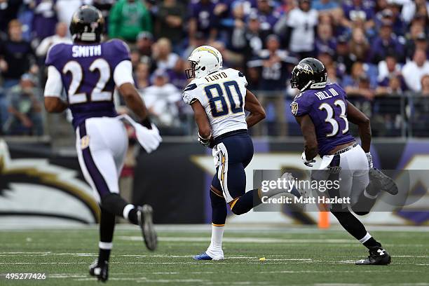 Wide receiver Malcom Floyd of the San Diego Chargers scores a third quarter touchdown past strong safety Will Hill of the Baltimore Ravens and...