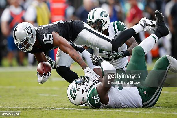 Michael Crabtree of the Oakland Raiders breaks a tackle from Demario Davis of the New York Jets as he runs for a 36-yard touchdown reception against...