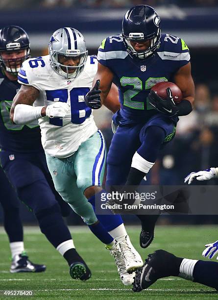 Fred Jackson of the Seattle Seahawks leaps through an opening against Greg Hardy of the Dallas Cowboys in the first quarter at AT&T Stadium on...