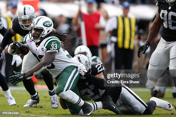 Chris Ivory of the New York Jets is tackled by Taylor Mays of the Oakland Raiders during their NFL game at O.co Coliseum on November 1, 2015 in...