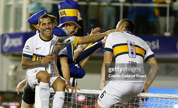 Carlos Tevez of Boca Juniors celebrates after winning the local soccer tournament holding the trophy after a match between Boca Juniors and Tigre as...