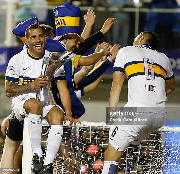 Carlos Tevez of Boca Juniors celebrates after winning the local soccer tournament holding the trophy after a match between Boca Juniors and Tigre as...