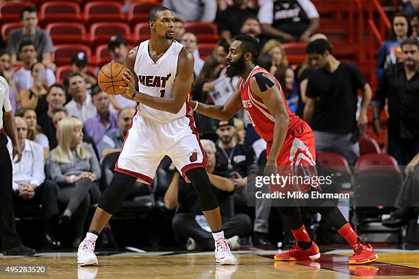 Chris Bosh of the Miami Heat posts up James Harden of the Houston Rockets during a game at American Airlines Arena on November 1, 2015 in Miami,...