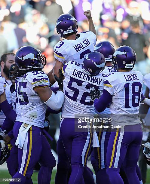 Blair Walsh of the Minnesota Vikings is lifted up by teammate Chad Greenway as the celebrate after Walsh kicked the game-winning field goal against...