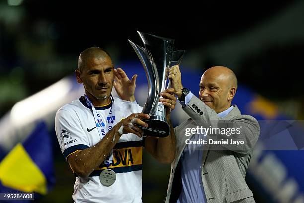 Daniel Díaz of Boca Juniors holds the trophy after winning the local soccer tournament holding the trophy after a match between Boca Juniors and...